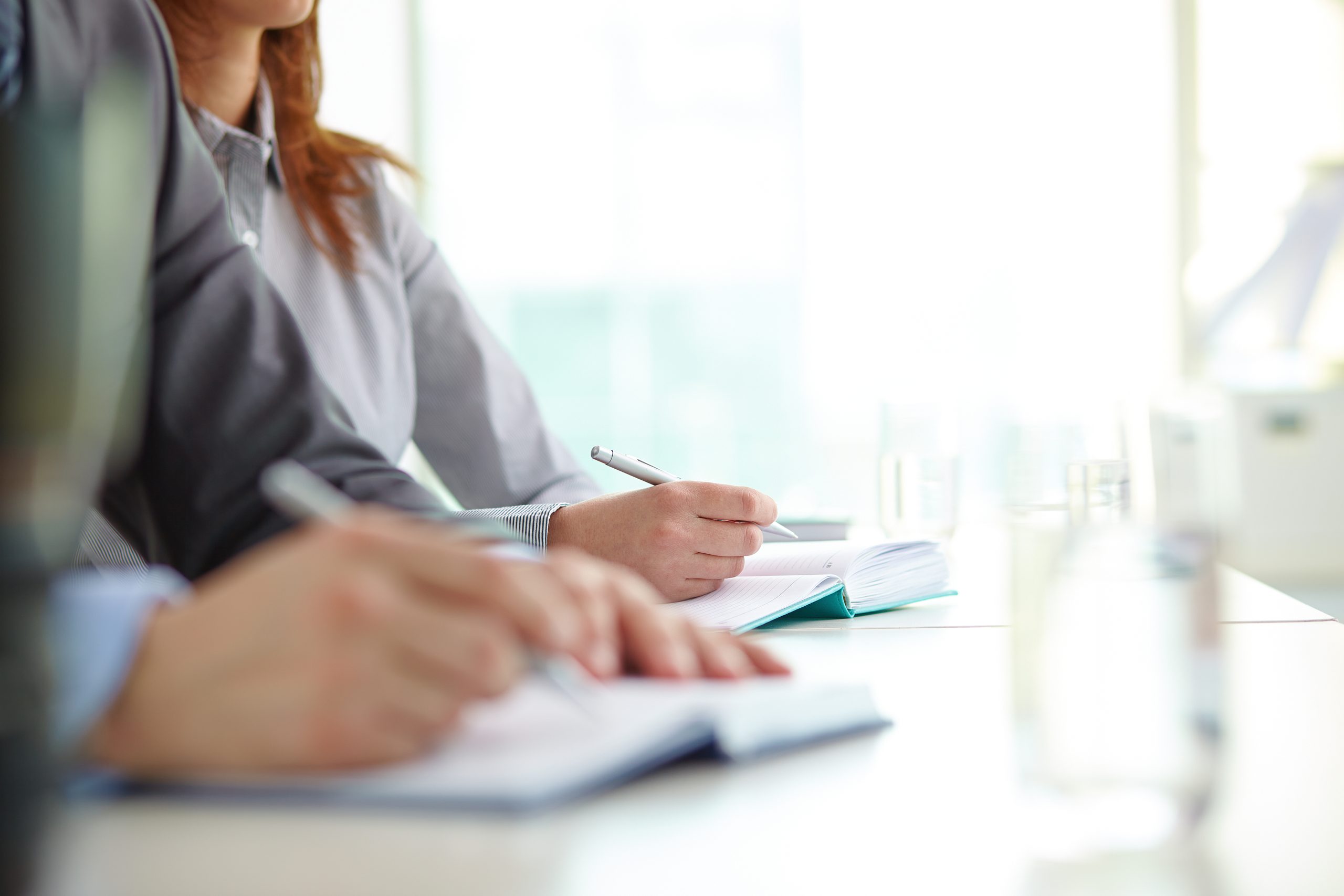 Empresaria anotando la contabilidad de un curso de formación en un cuaderno